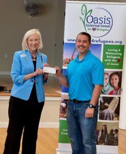 chapter regent presents check to man from Oasis International