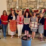 chapter women standing with sparkle in service sign next to patriotic decorations