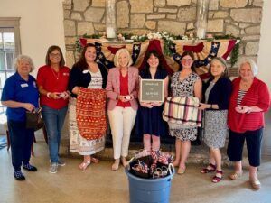 chapter women standing with sparkle in service sign next to patriotic decorations