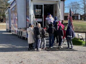 school children entering Wreaths Across America exhib housed in semi truck