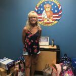 woman standing with donations of school supplies for a nonprofit