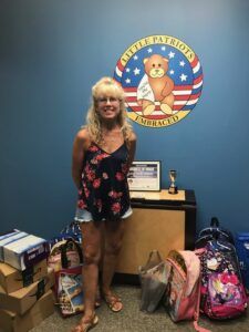 woman standing with donations of school supplies for a nonprofit