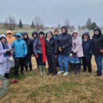 A group of volunteers placed wreaths on gravestones at Jefferson Barracks National Cemetery.