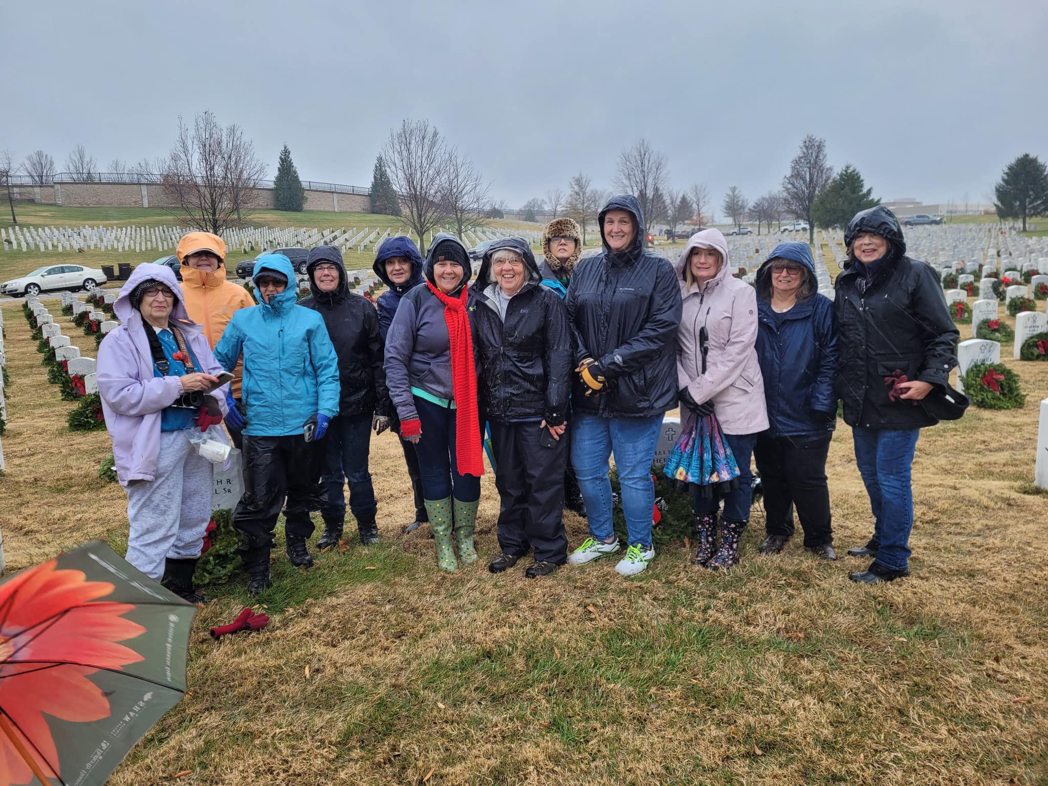 A group of volunteers placed wreaths on gravestones at Jefferson Barracks National Cemetery.